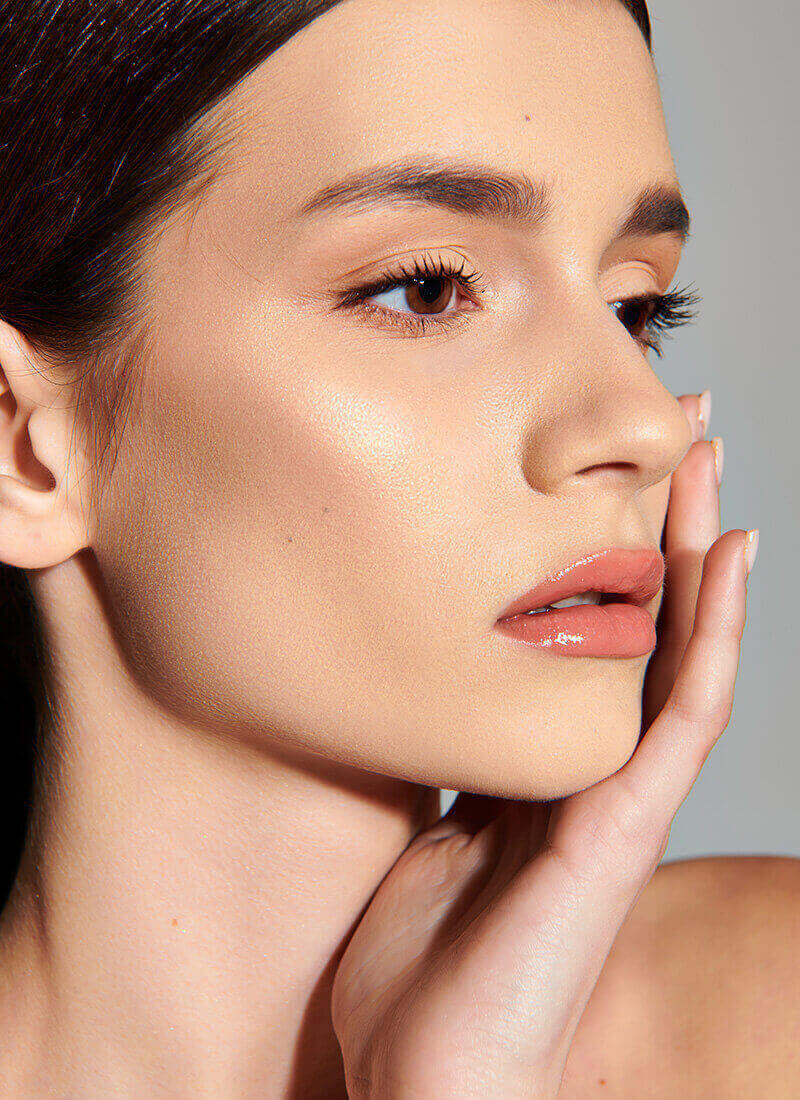 woman with an amazing jawline hold her hand to her cheek