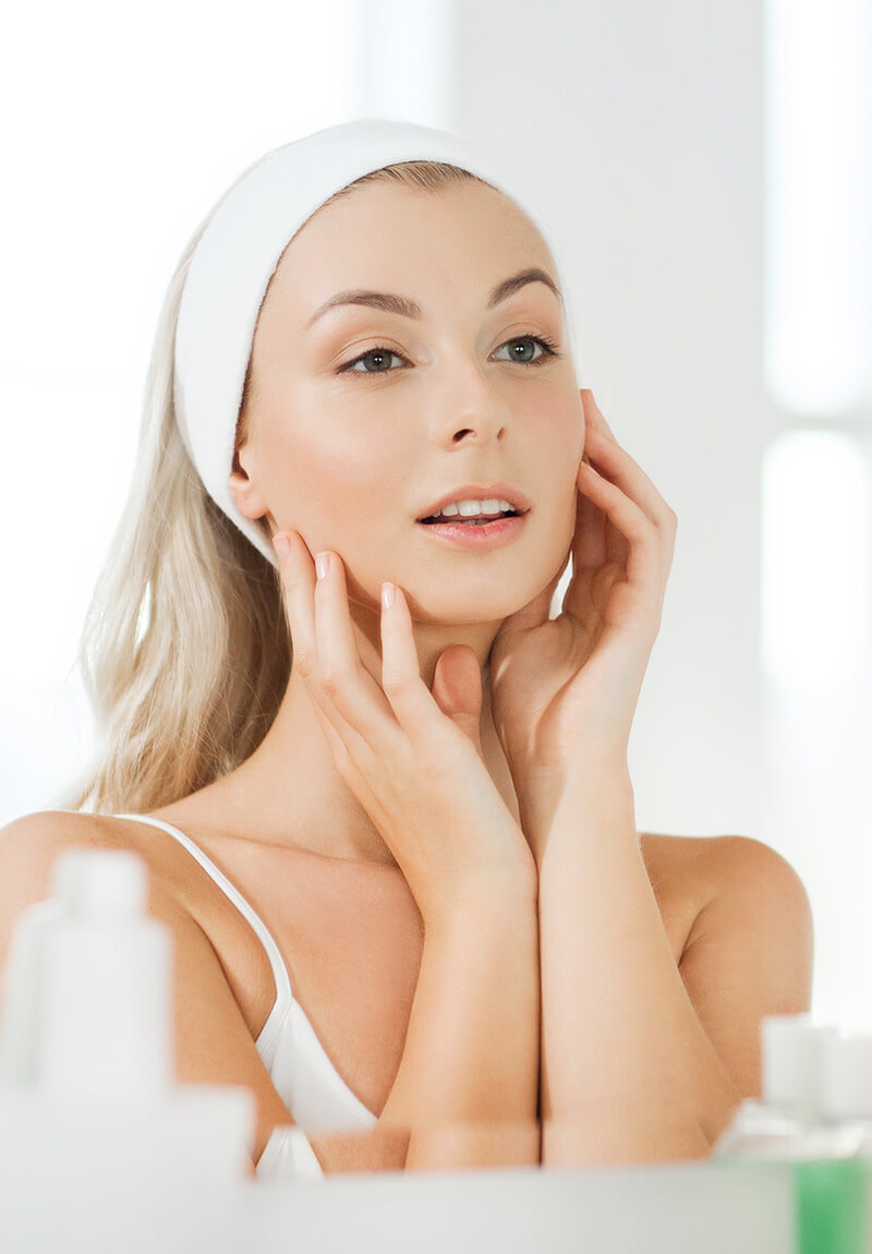 Woman with nice skin looking in the mirror