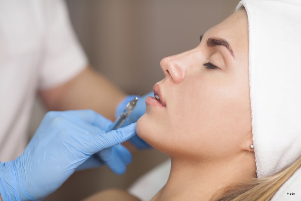 Doctor applying an injection to a woman's face.